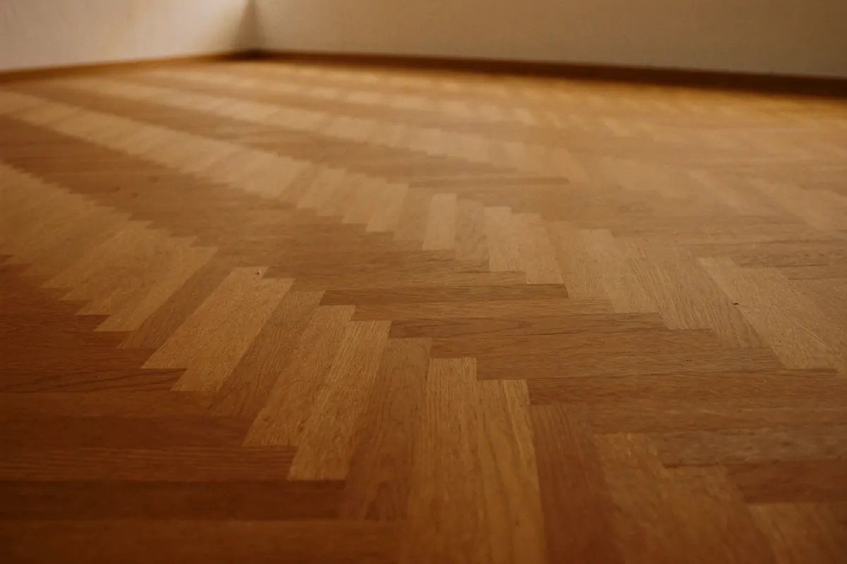 A herringbone parquet floor of short oak blocks laid in a zigzag
